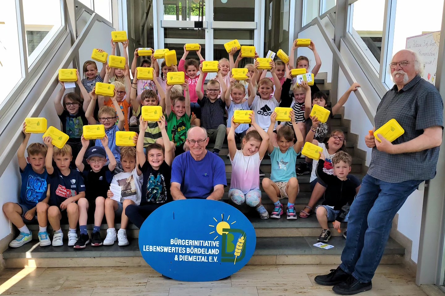 Kinder halten gelbe Bio-Brotboxen hoch