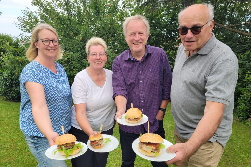 Vier Bio-Börde-Burger auf Tellern präsentiert.