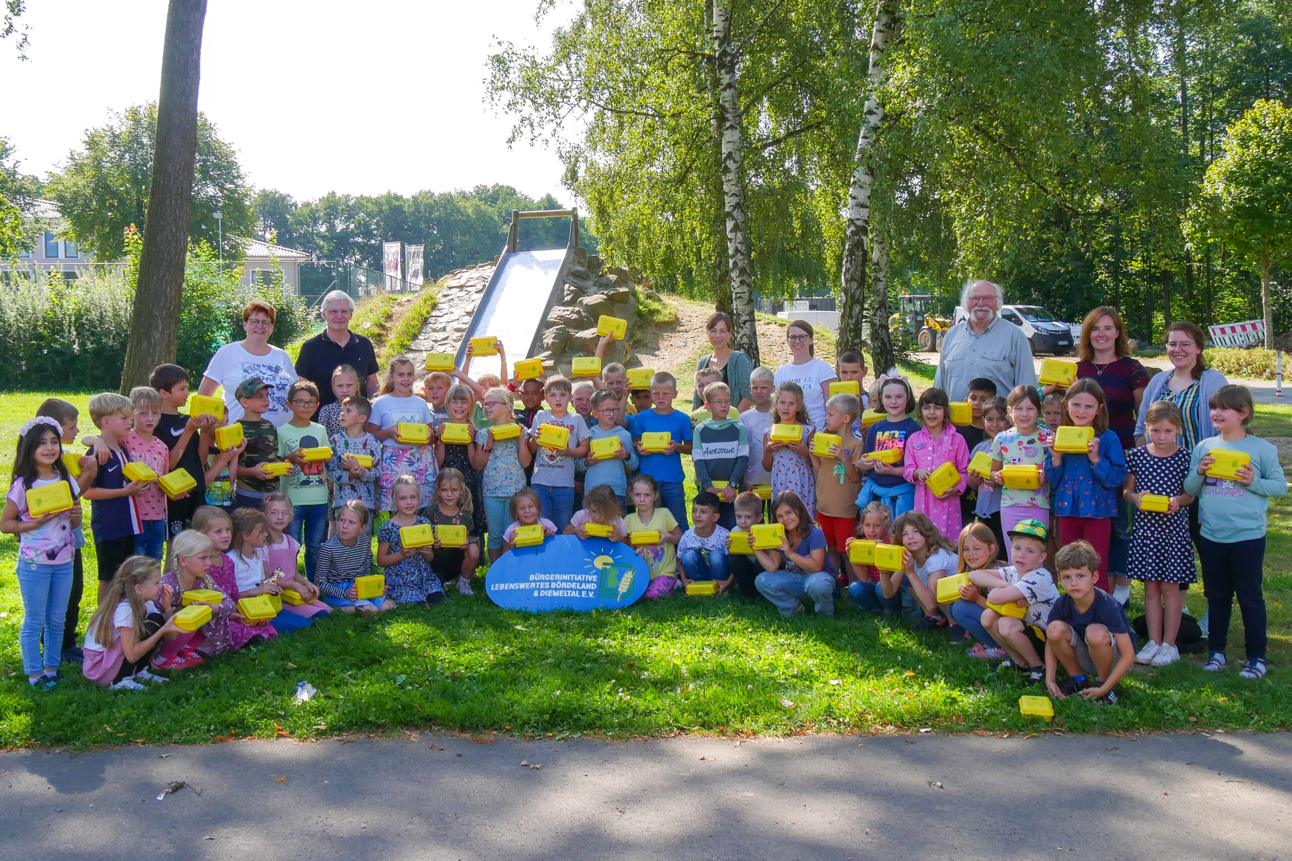 Kinder mit gelben Bio-Brotboxen auf dem Pausenhof der Grundschule Willebadessen.