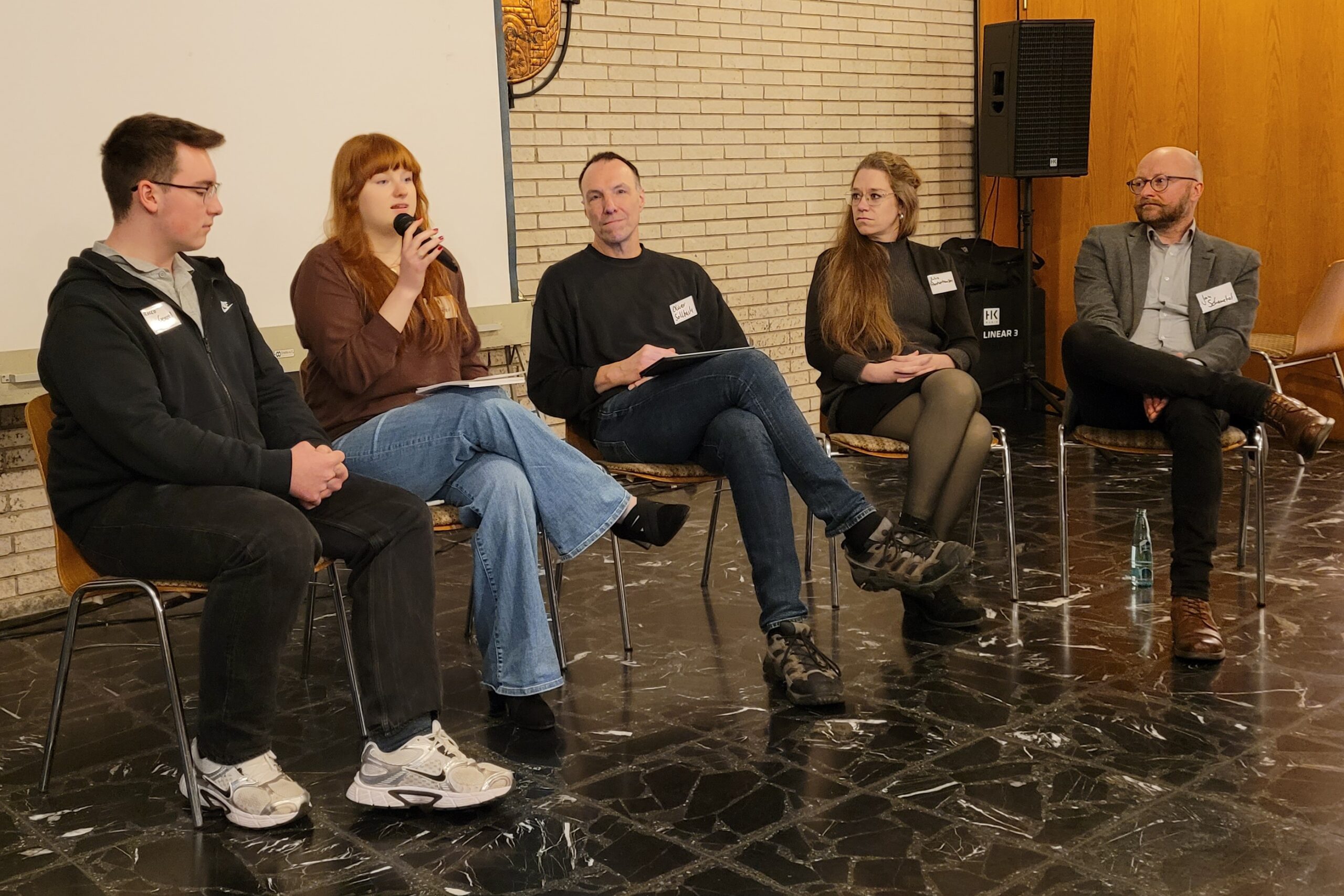 Fünf Personen diskutieren beim Netzwertreffen Dreiländereck auf dem Podium im Bürgerhaus Helmarshausen.